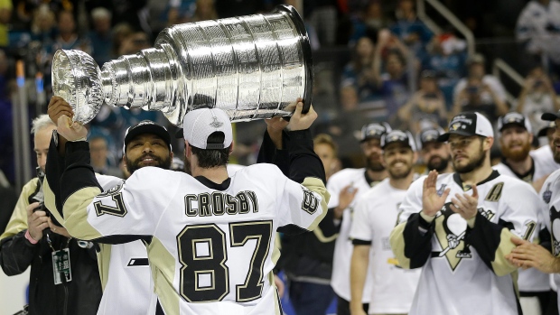 Sidney Crosby hands the Stanley Cup to Trevor Daley