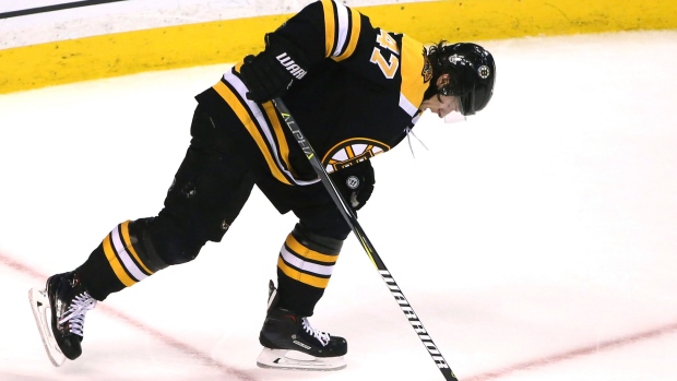 Boston Bruins' Torey Krug gets off a pass as he falls to the ice during the  first period of an NHL hockey game against the Pittsburgh Penguins in  Pittsburgh, Sunday, March 10