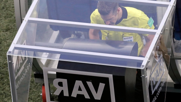 Referee watches the Video Assistant Referee system, The Canadian Press Referee watches the Video Assistant Referee system