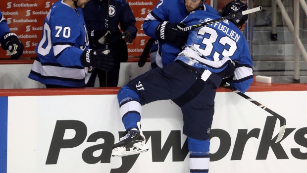 Ben Chiarot helps Dustin Byfuglien onto bench, The Canadian Press Ben Chiarot helps Dustin Byfuglien onto bench