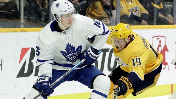 Toronto's Mitch Marner fends off Nashville's Calle Jarnkrok Tuesday night.
