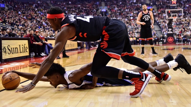 Raptors forward Pascal Siakam and Magic forward Jonathan Isaac battle for the ball.