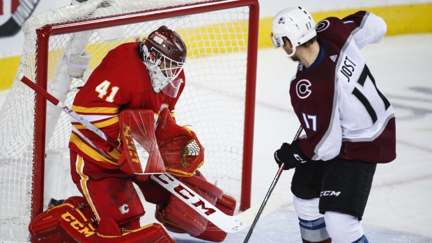 Tyson Jost, right, has his shot stopped by Calgary Flames goalie Mike Smith