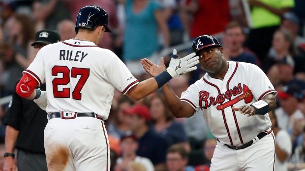Austin Riley celebrates with first base coach Eric Young