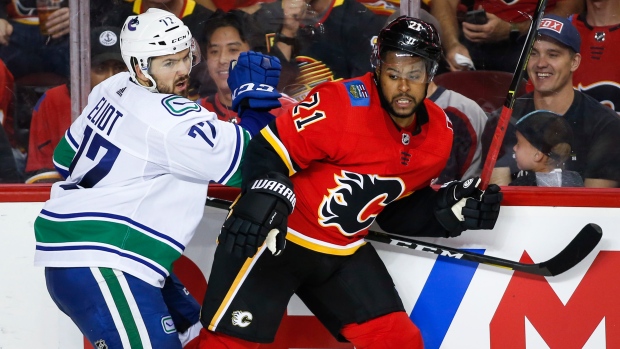 Mitch Eliot, left, checks Calgary Flames' Devante Smith-Pelly