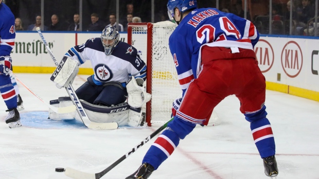 Jets goalie Connor Hellebuyck sets up for a shot by Rangers winger Kaapo Kakko., The Canadian Press Jets goalie Connor Hellebuyck sets up for a shot by Rangers winger Kaapo Kakko.