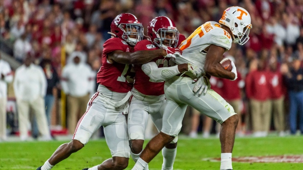 Xavier McKinney (15) and Jared Mayden (21) drag down Tennessee wide receiver Jauan Jennings (15)