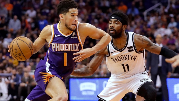 Devin Booker (1) drives past Brooklyn Nets guard Kyrie Irving (11) 