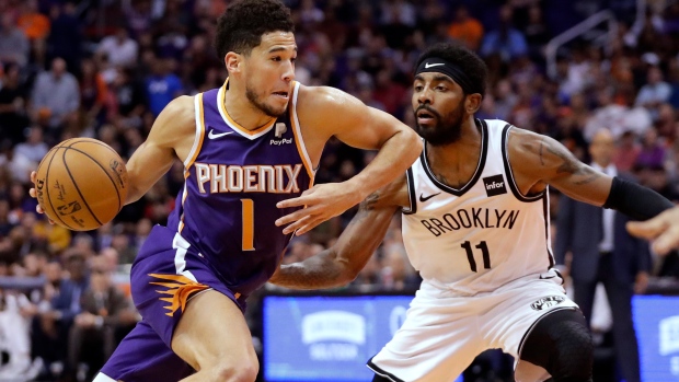 Devin Booker (1) drives past Brooklyn Nets guard Kyrie Irving (11) , The Canadian Press Devin Booker (1) drives past Brooklyn Nets guard Kyrie Irving (11)