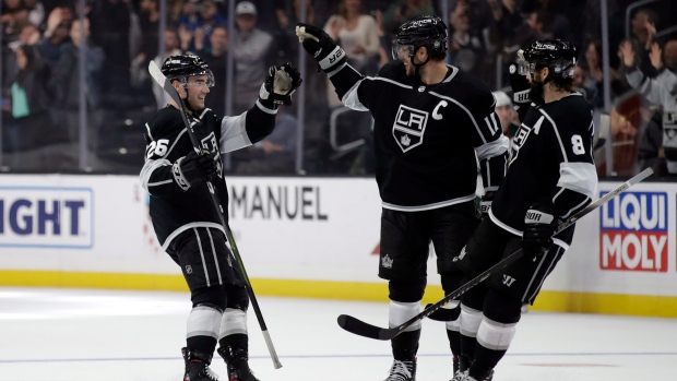 Sean Walker, left, celebrates his goal with Anze Kopitar, center, and Drew Doughty (8)