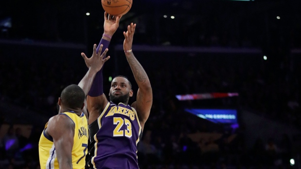 Los Angeles Lakers' LeBron James (23) shoots between Golden State Warriors' Eric Paschall