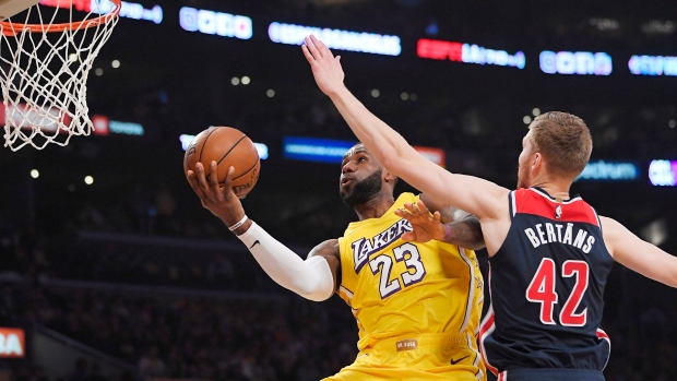 LeBron James, left, shoots as Davis Bertans