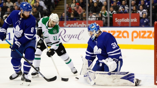 Frederik Andersen makes a save on Stars centre Andrew Cogliano as Jake Muzzin looks on.