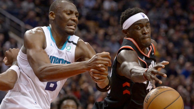 Hornets centre Bismack Biyombo and Raptors forward Pascal Siakam battle for the ball Friday.