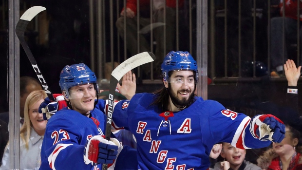 Adam Fox (23) and center Mika Zibanejad (93) celebrate