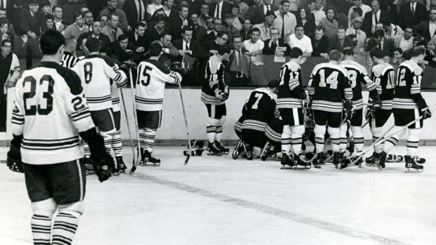Boston Bruins stand over a fallen Bobby Orr