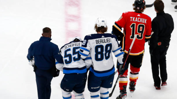 Mark Scheifele helped off the ice