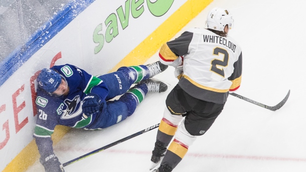 Vegas Golden Knights' Zach Whitecloud and Vancouver Canucks' Antoine Roussel 