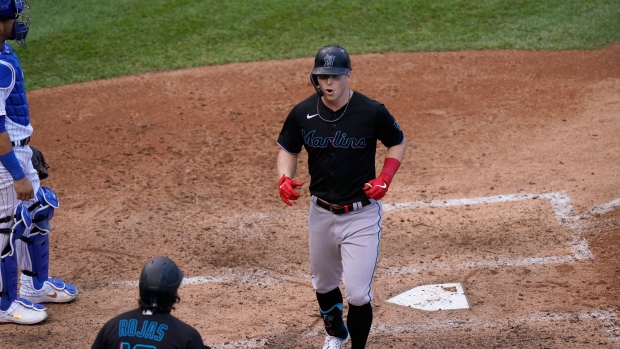 Cubs catcher Willson Contreras stands by as Marlins' Miguel Rojas celebrates with Corey Dickerson