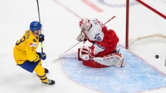 Sweden's Emil Heineman (13) scores on Czech Republic goalie Nick Malik (30)