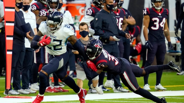 Tennessee Titans' Derrick Henry breaks away from Houston Texans safety A.J. Moore Jr.