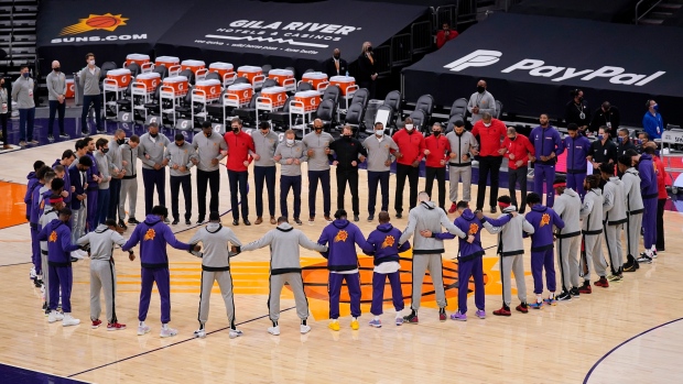Phoenix Suns and the Toronto Raptors form a circle , The Canadian Press Phoenix Suns and the Toronto Raptors form a circle