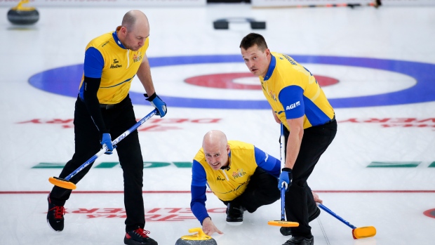 Team Wild Card Two skip Kevin Koe, centre, makes a shot at the Brier