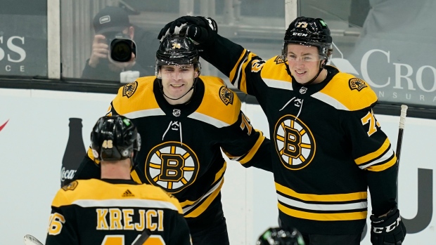 Jake DeBrusk (74) celebrates his goal with Charlie McAvoy (73) and David Krejci (46)