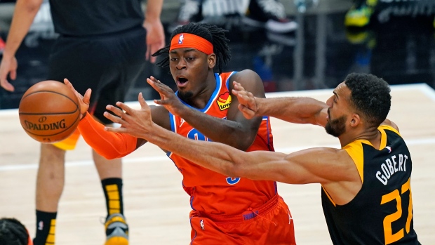 Thunder's Luguentz Dort passes the ball while defended by Jazz center Rudy Gobert