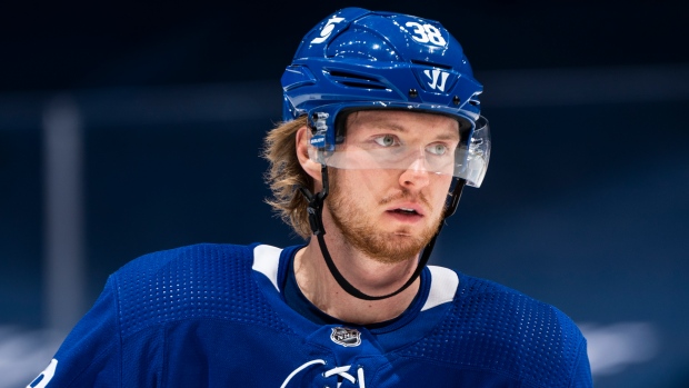 Morgan Rielly of the Toronto Maple Leafs cross checks Rasmus