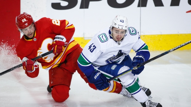 Vancouver Canucks' Quinn Hughes and Calgary Flames' Elias Lindholm