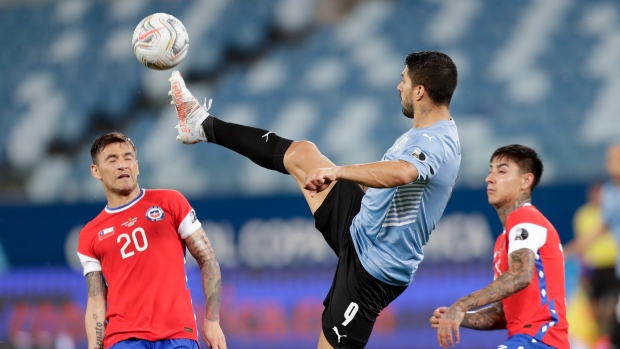 Uruguay's Luis Suarez, center controls the ball during a match against Chile 
