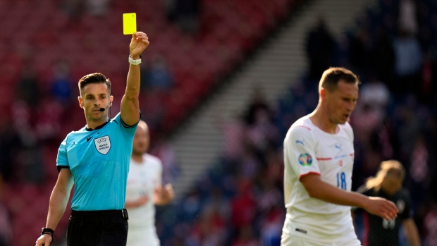 Carlos del Cerro Grande, left, shows a yellow card to Czech Republic's Jan Boril