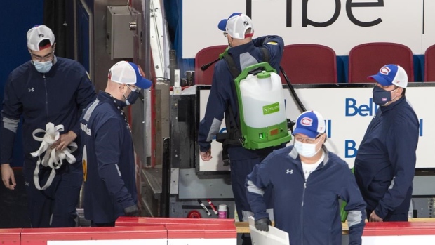 Workers sanitize the benches at the Bell Centre