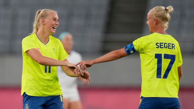 Stina Blackstenius, left, celebrates with teammate Caroline Seger