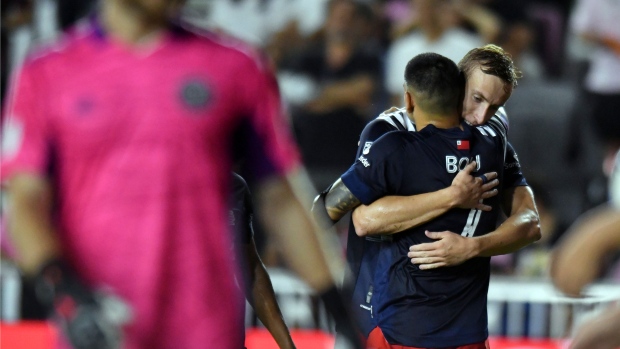 New England Revolutions Adam Buksa hugs Gustavo Bou 