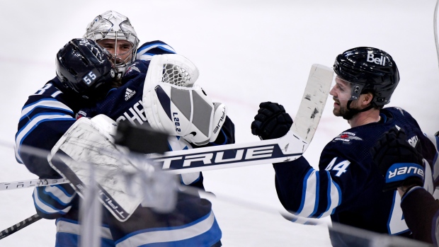 Mark Scheifele and Connor Hellebuyck celebrate