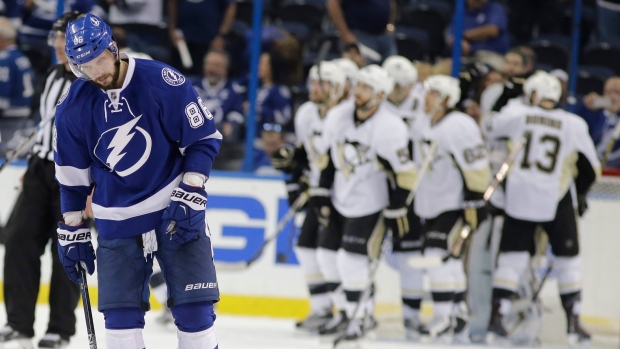 Nikita Kucherov stands in front of celebrating Penguins