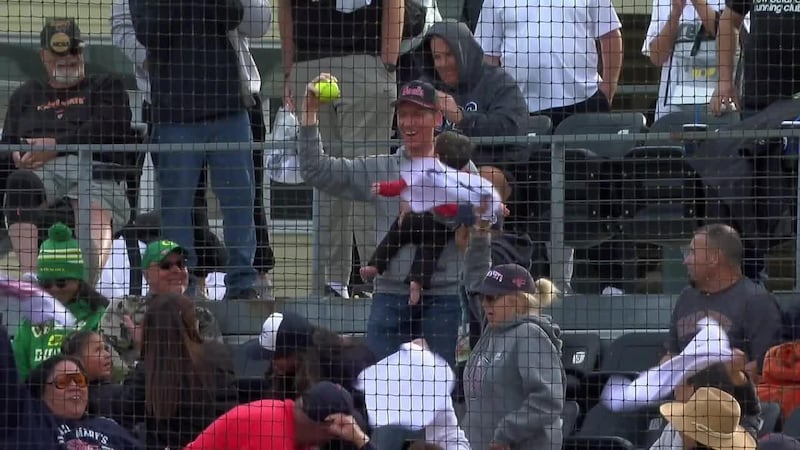 Fan holding baby catches a foul ball during Saint Mary's-Mississippi State game
